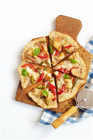 simsearch:600-06382994,k - Chicken and Roasted Vegetable, homemade white Pizza, on a Cutting board with Pizza Cutter and Napkin, studio shot on white background Stock Photo - Premium Royalty-Free, Code: 600-08002093