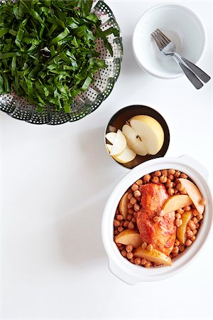 simsearch:600-06382994,k - Casserole with tandoori chicken, chickpeas and asian pear with steamed collards on the side, studio shot on white background Stock Photo - Premium Royalty-Free, Code: 600-08002128
