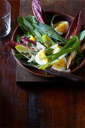 Leafy green salad with boiled egg and parmesan in a wood bowl, studio shot on dark, wooden background Foto de stock - Sin royalties Premium, Código: 600-08002134
