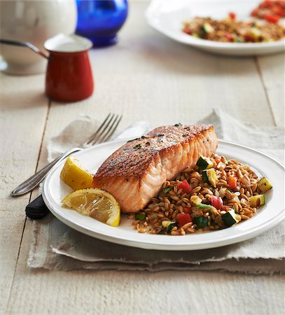 fish seafood dish - Seared Salmon with grain pilaf and lemons on a plate, studio shot Stock Photo - Premium Royalty-Free, Code: 600-08002163
