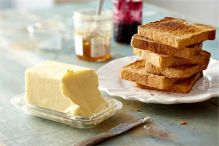 Stack of Whole Wheat Toast on Plate with Block of Butter and Jam on Tabletop Stock Photo - Premium Royalty-Free, Code: 600-08002401