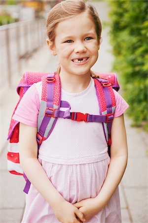 5 Year Old Schoolgirl with Pink School Bag Smiling with Missing Teeth Stock Photo - Premium Royalty-Free, Code: 600-08416837
