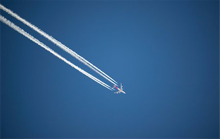 enroute - Airplane and contrails against blue sky, Canada Stock Photo - Premium Royalty-Free, Code: 600-08523355