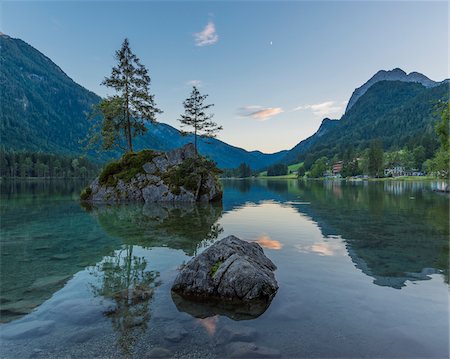 scenery with calm waters - Lake Hintersee with mountains and trees growing on small, rock island at dawn at Ramsau in the Berchtesgaden National Park in Upper Bavaria, Bavaria, Germany Stock Photo - Premium Royalty-Free, Code: 600-09022461