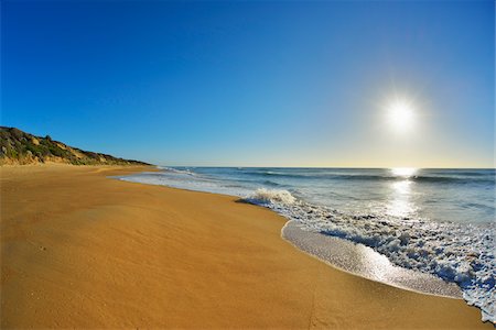 simsearch:600-07453834,k - Surf breaking on the shoreline of Ninety Mile Beach at Paradise Beach with the sun shining over the ocean in Victoria, Australia Stock Photo - Premium Royalty-Free, Code: 600-09052849