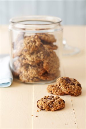 simsearch:600-07067653,k - Oatmeal cookies in a glass cookie jar on a cream colored wood surface Stock Photo - Premium Royalty-Free, Code: 600-09119364
