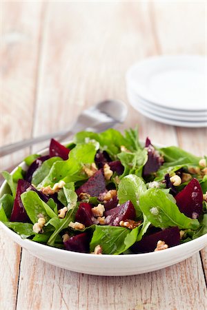 simsearch:700-03053816,k - Beet salad with baby greens and walnuts in a bowl with serving utensils and side plates Stock Photo - Premium Royalty-Free, Code: 600-09119408