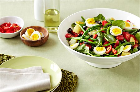 simsearch:700-03053816,k - Nicoise Salad with eggs, green beans, tomatoes and olives on a green linen tablecloth Stock Photo - Premium Royalty-Free, Code: 600-09155466