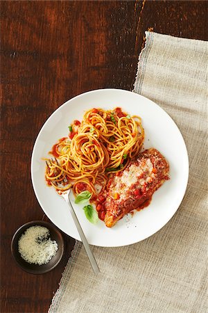 simsearch:600-06382994,k - Plate of chicken parmesan with spaghetti and tomato sauce and a side dish with a fork and a side dish of cheese on a wooden background Stock Photo - Premium Royalty-Free, Code: 600-09155500