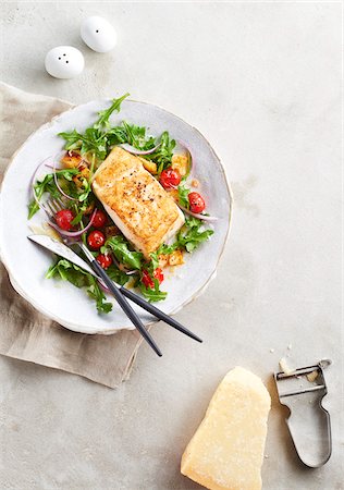 simsearch:600-06382994,k - Halibut with arugula and cherry tomato salad served with shaved parmesan cheese Stock Photo - Premium Royalty-Free, Code: 600-09155571