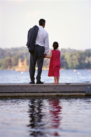 Back View of Father and Daughter Standing on Dock, Holding Hands Stock Photo - Premium Royalty-Free, Code: 600-00064731