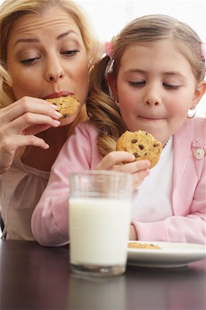 Mother and Daughter Eating Milk and Cookies Stock Photo - Premium Royalty-Free, Code: 600-00845884