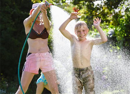 Mother Spraying Son With Hose Stock Photo - Premium Royalty-Free, Code: 600-00847731
