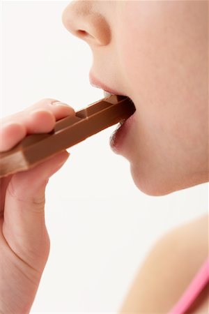 Girl Biting Chocolate Bar Stock Photo - Premium Royalty-Free, Code: 600-00847929