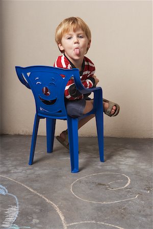 simsearch:700-00078438,k - Boy Sitting in Chair, Sticking Out Tongue Stock Photo - Premium Royalty-Free, Code: 600-00848641