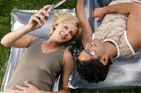 Couple Looking at Camera Phone Stock Photo - Premium Royalty-Free, Code: 600-00864516