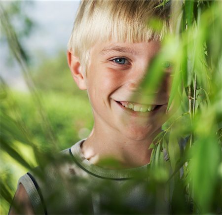 Boy Looking Through Foliage Stock Photo - Premium Royalty-Free, Code: 600-00866540