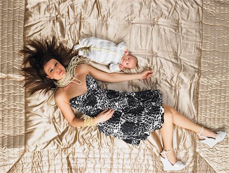 Woman Lying on Bed with Baby Stock Photo - Premium Royalty-Free, Code: 600-00917276