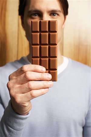 simsearch:600-02033679,k - Man Covering Face with Bar of Chocolate Stock Photo - Premium Royalty-Free, Code: 600-00934348