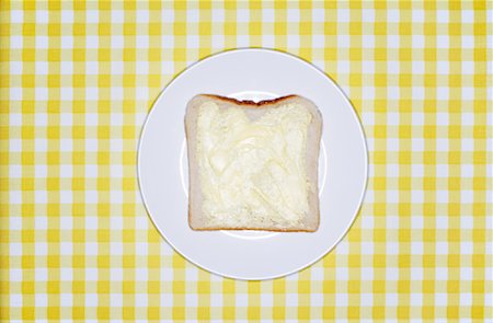 Slice of Bread with Butter on Plate Stock Photo - Premium Royalty-Free, Code: 600-00933847