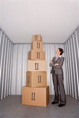 Woman Looking at Pile of Boxes in Storage Stock Photo - Premium Royalty-Free, Code: 600-00933841