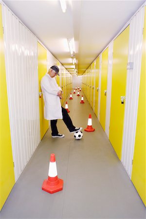 Soccer Coach with Pylons and Soccer Ball in Hallway Stock Photo - Premium Royalty-Free, Code: 600-00933873