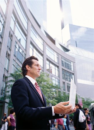 simsearch:700-00281308,k - Businessman Holding Laptop Computer in City Stock Photo - Premium Royalty-Free, Code: 600-00948871
