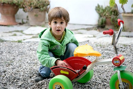 simsearch:700-00280017,k - Boy Putting Small Stones in Tricycle Stock Photo - Premium Royalty-Free, Code: 600-00954661