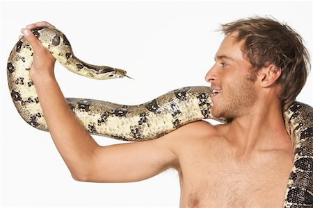 Close-up of Man and Snake Looking at Each Other Stock Photo - Premium Royalty-Free, Code: 600-00984435