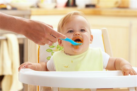 dirty and messy kitchen - Baby being Fed in High Chair Stock Photo - Premium Royalty-Free, Code: 600-01015384