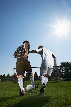 soccer player kicking ball into the goal - Men Playing Soccer Stock Photo - Premium Royalty-Free, Code: 600-01037276