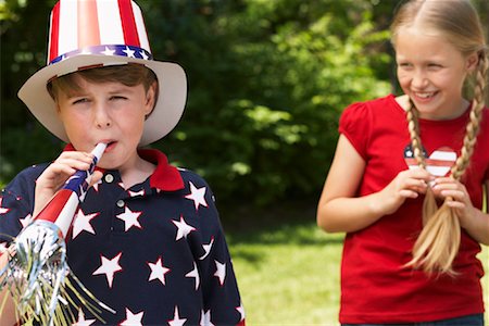 simsearch:700-00092986,k - Portrait of Boy Wearing Stars and Stripes Top and Hat, Blowing Noisemaker Horn, Girl Watching Stock Photo - Premium Royalty-Free, Code: 600-01041996