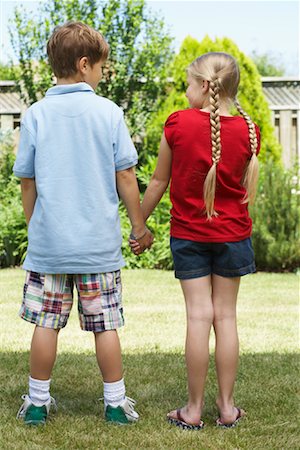 Backview of Boy and Girl Standing in Backyard Holding Hands Stock Photo - Premium Royalty-Free, Code: 600-01042002