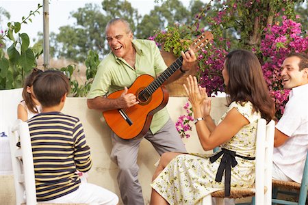 simsearch:600-02348915,k - Famille assis à l'extérieur en profitant l'homme jouer de la guitare Photographie de stock - Premium Libres de Droits, Code: 600-01043412