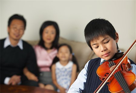 picture of young boy holding violin - Portrait de garçon jouant le violon tout en famille montres Photographie de stock - Premium Libres de Droits, Code: 600-01073080