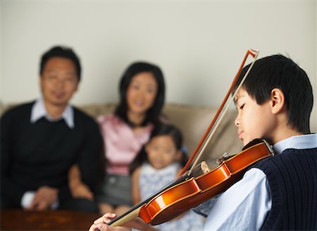 picture of young boy holding violin - Portrait de garçon jouant le violon tout en famille montres Photographie de stock - Premium Libres de Droits, Code: 600-01073081