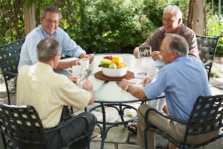 simsearch:600-01073505,k - Men Sitting Outdoors Looking at Photos Foto de stock - Sin royalties Premium, Código: 600-01073519