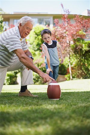 football in the backyard - Grandfather and Grandson Playing Football Stock Photo - Premium Royalty-Free, Code: 600-01073539