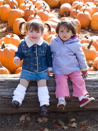 Girls Sitting in Pumpkin Patch Stock Photo - Premium Royalty-Free, Code: 600-01083493