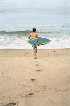 simsearch:673-06964643,k - Man Carrying Surfboard into Water Stock Photo - Premium Royalty-Free, Code: 600-01099689