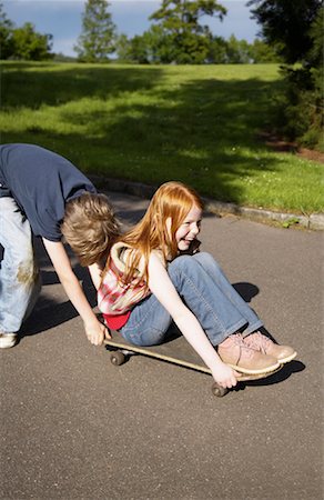 skating in the street - Boy Pushing Girl on Skateboard Stock Photo - Premium Royalty-Free, Code: 600-01100114