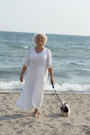 Woman Walking Dog on Beach Stock Photo - Premium Royalty-Free, Code: 600-01119931