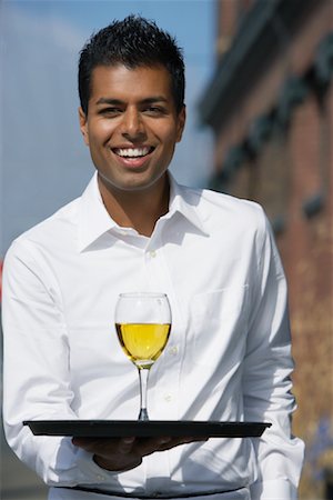simsearch:600-01646509,k - Waiter Carrying Glass of Wine Outdoors Stock Photo - Premium Royalty-Free, Code: 600-01111984