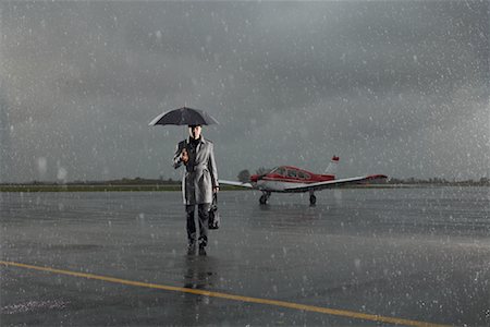 servicing a plane - Businessman Walking on Tarmac in Rainy Weather Stock Photo - Premium Royalty-Free, Code: 600-01174004