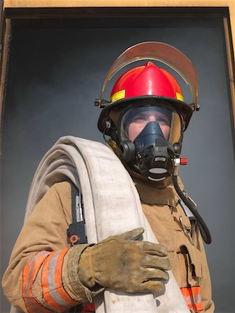 Firefighter Carrying Hose out of Smoky Building Stock Photo - Premium Royalty-Free, Code: 600-01172197