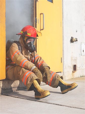 Firefighter in Doorway of Smoke-filled Building Stock Photo - Premium Royalty-Free, Code: 600-01172215