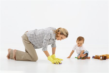Mother Scrubbing Floor, Baby Playing Foto de stock - Sin royalties Premium, Código: 600-01172794