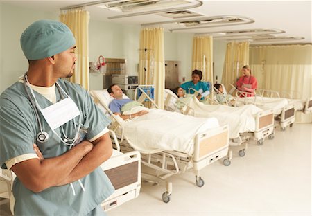 simsearch:600-01248237,k - Nurses Tending to Patients while Doctor Watches Stock Photo - Premium Royalty-Free, Code: 600-01236204