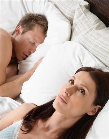 Woman Lying Awake in Bed while Man Sleeps Foto de stock - Sin royalties Premium, Código: 600-01295825