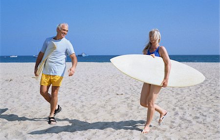 Couple Carrying Surfing Boards on Beach Stock Photo - Premium Royalty-Free, Code: 600-01296383